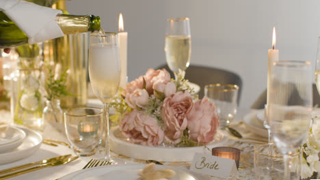 Nahaufnahme-Einer-Person,-Die-Bei-Der-Hochzeitsfeier-Champagner-In-Ein-Glas-Gießt,-Am-Gedeckten-Tisch-1